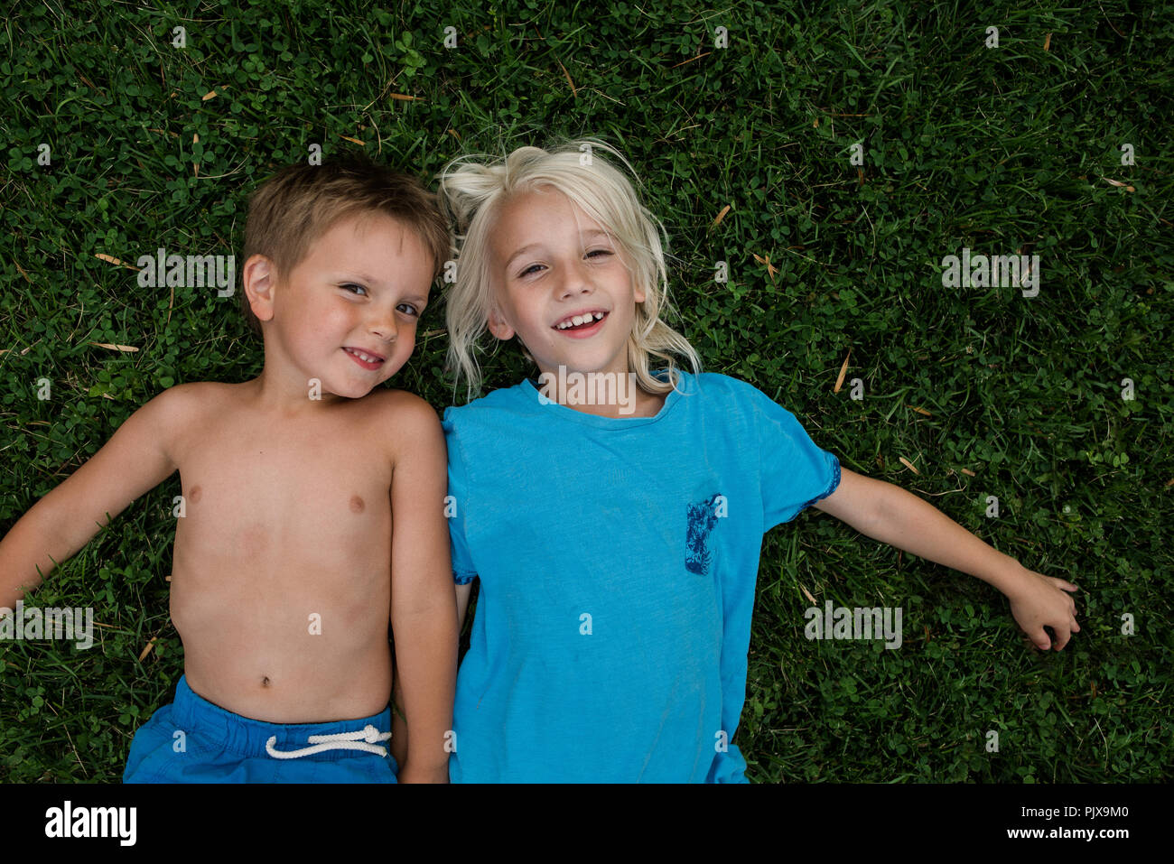 Children lying on grass Stock Photo