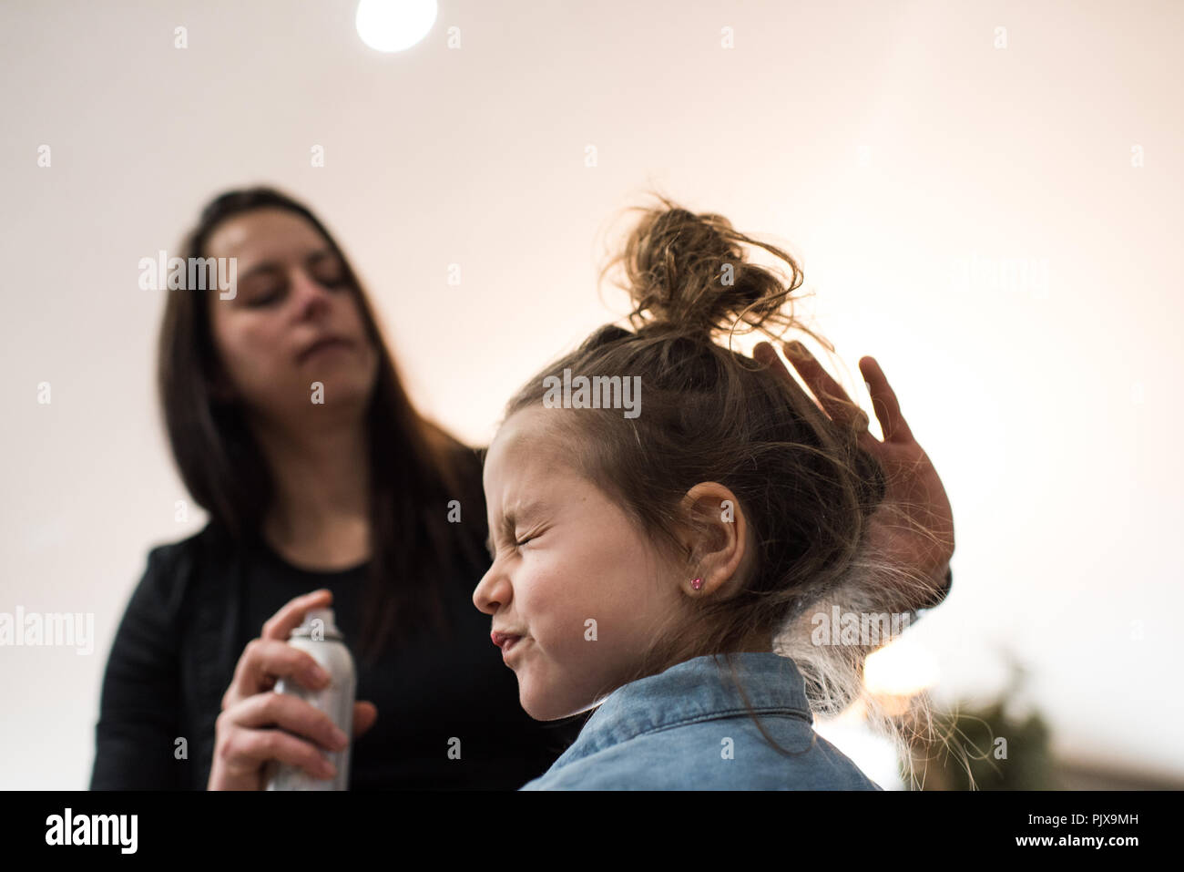 Mother tidying daughter's hair Stock Photo