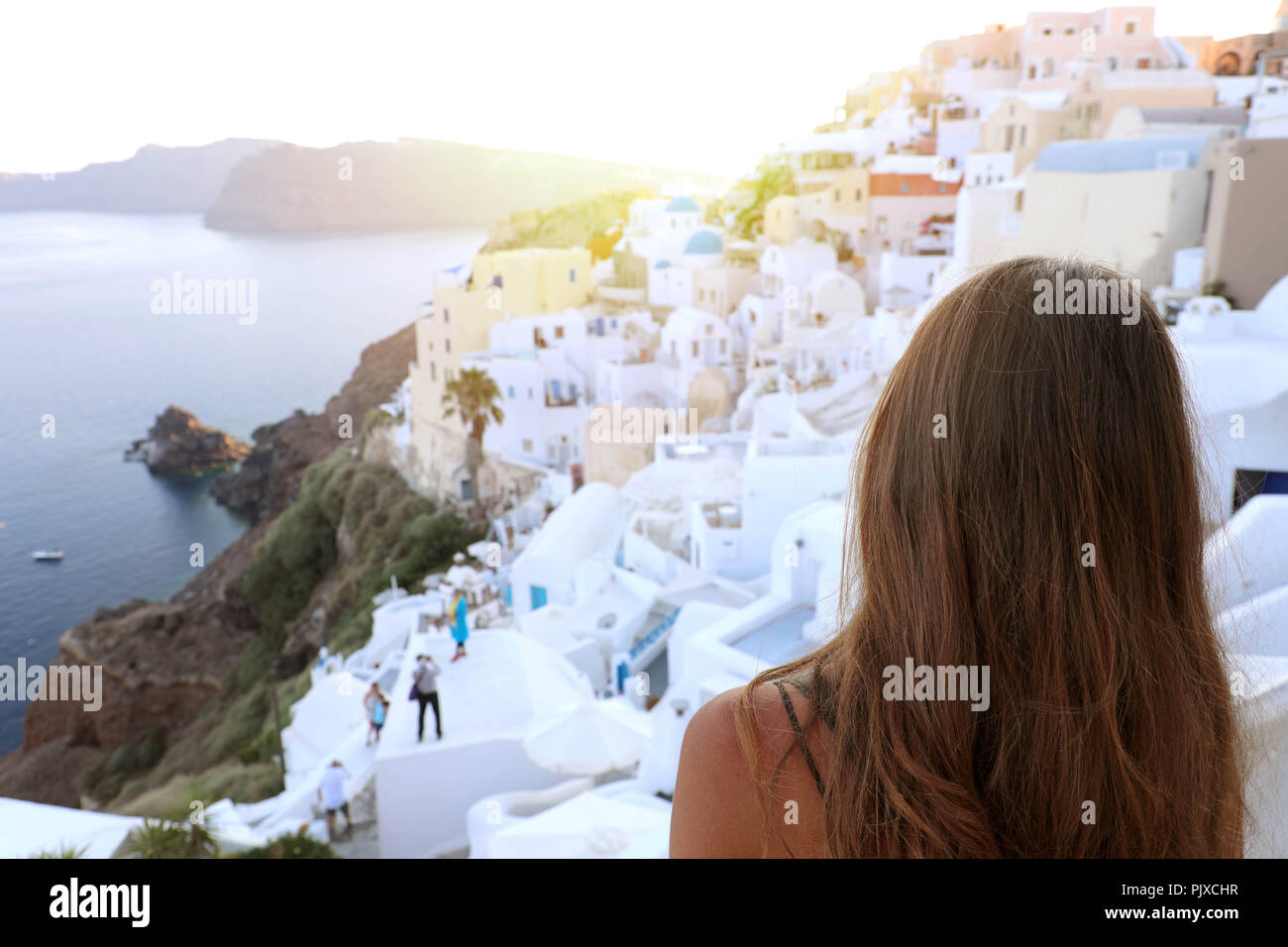Back view of beautiful young woman in Oia village, Santorini Stock Photo
