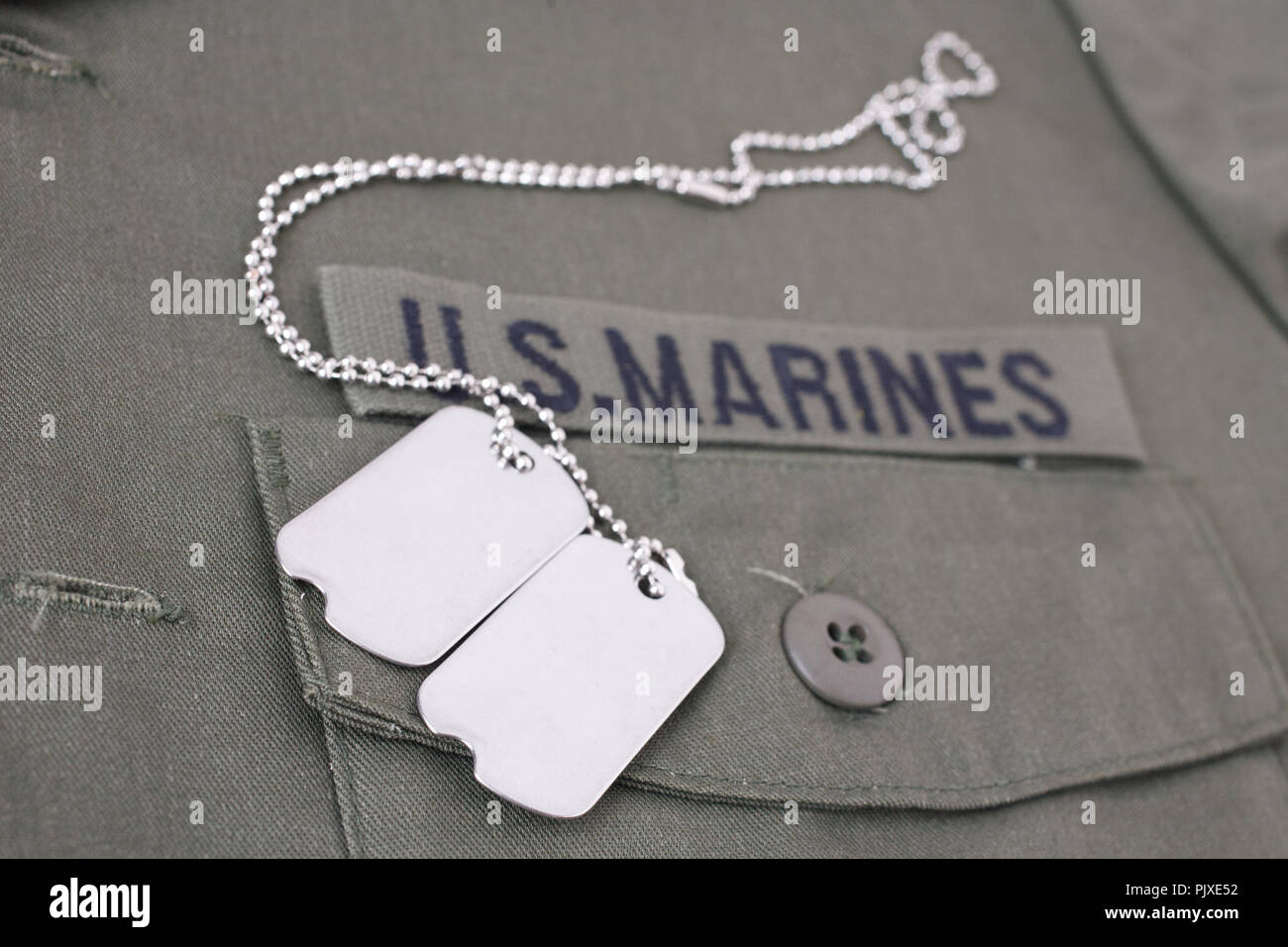 U.S. MARINES Tape with dog tags on olive green uniform background Stock