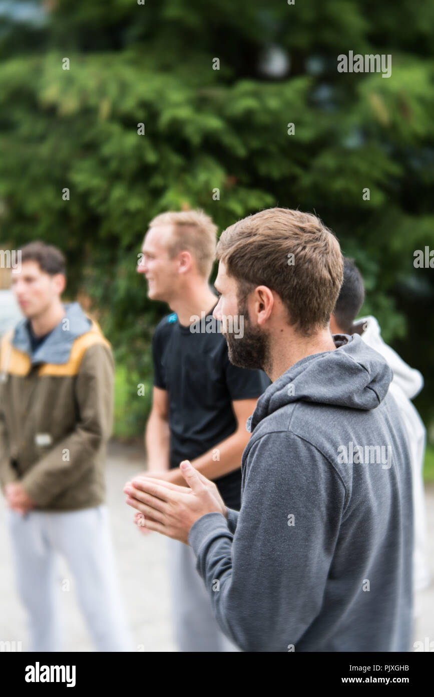 group of young people standing in a circle and praying together Stock Photo