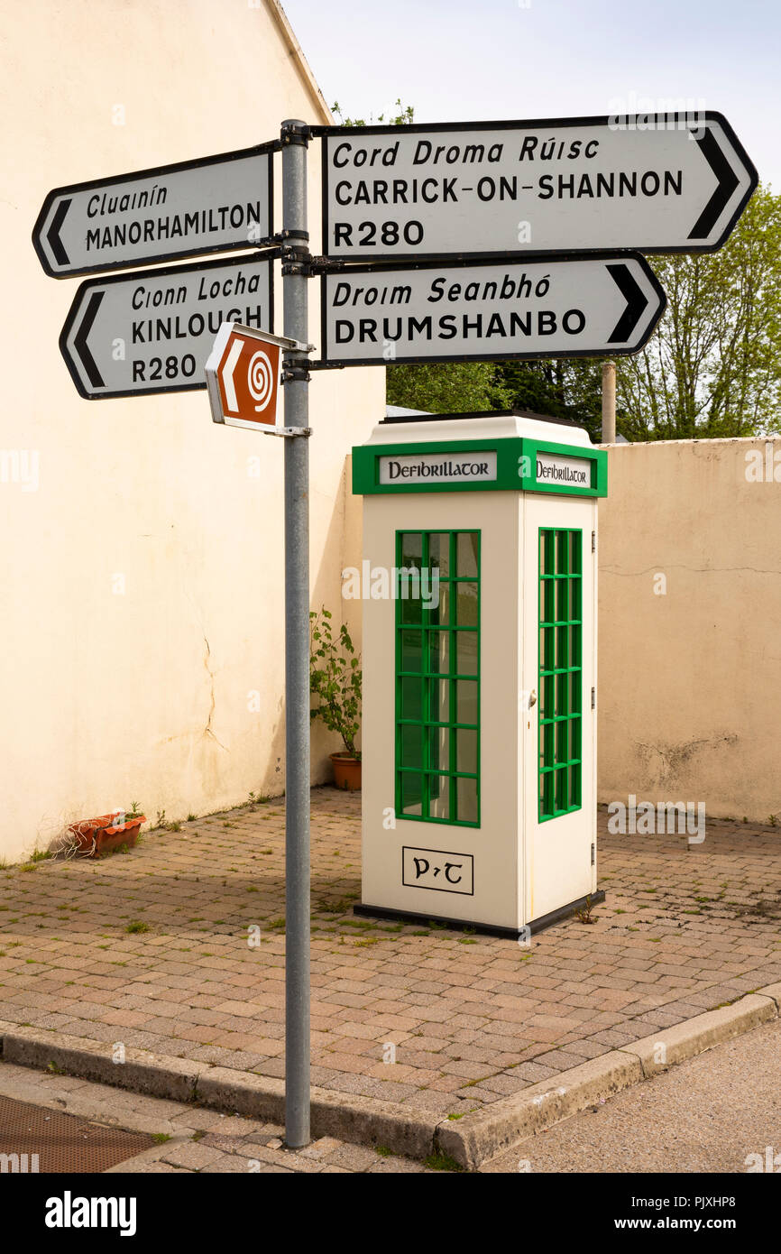 Ireland, Co Leitrim, Drumkeerin, redundant 1930s P&T telephone box converted to defibrillator beside road direction signs Stock Photo