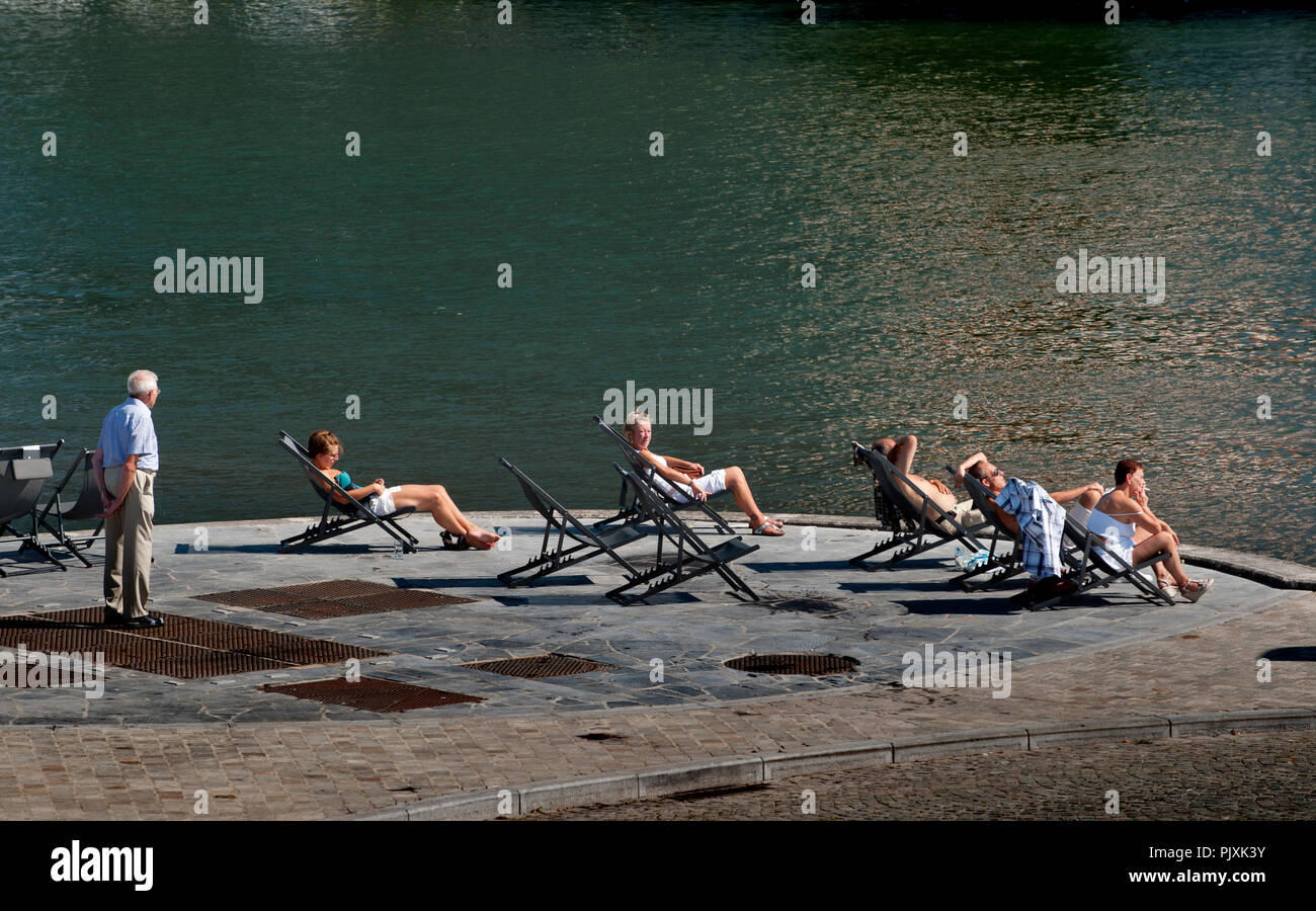 People sunbathing at the Grognon, historic centre of Namur along the Meuse river (Belgium, 04/09/2013) Stock Photo