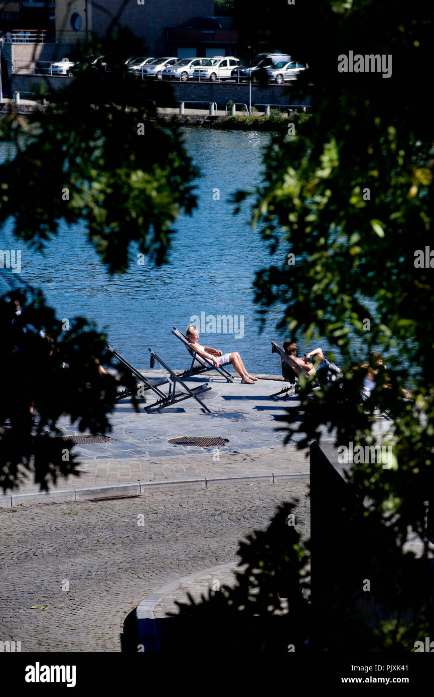 People sunbathing at the Grognon, historic centre of Namur along the Meuse river (Belgium, 04/09/2013) Stock Photo