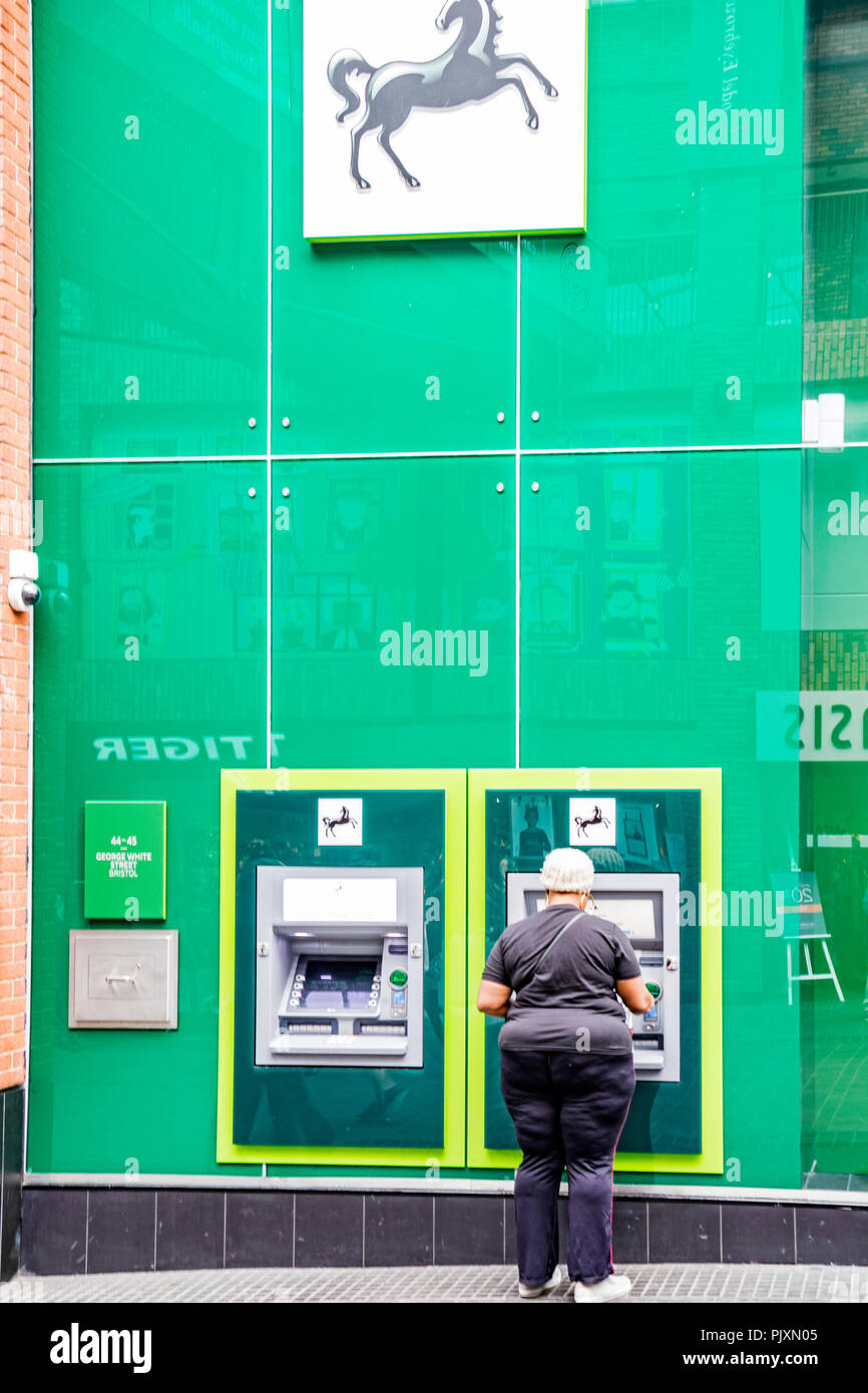 Lady using a Lloyds bank cash machine, Bristol, England, UK Stock Photo