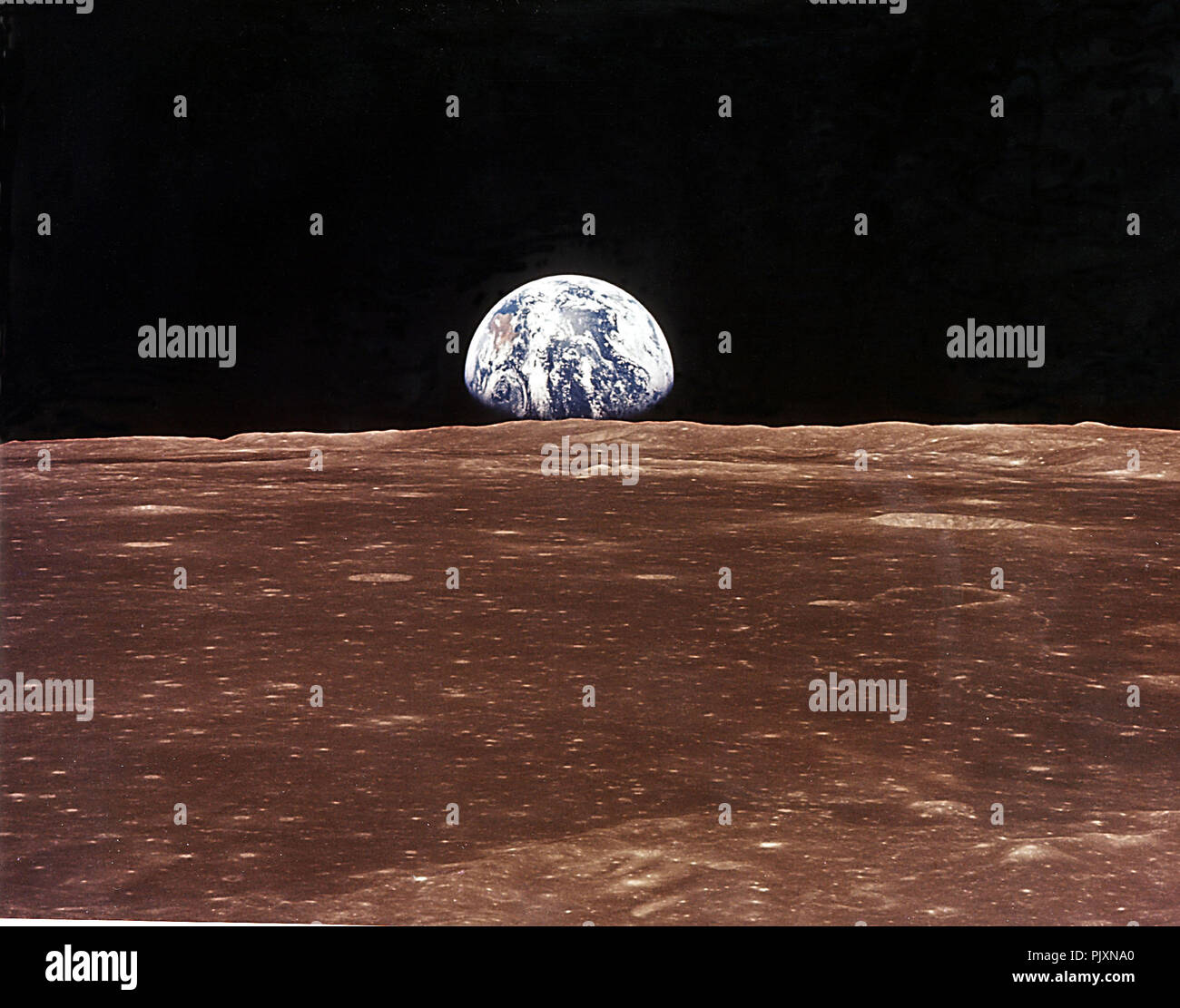 In Lunar Orbit - (FILE) -- This view of the rising Earth greeted the Apollo 11 astronauts as they came from behind the Moon after the lunar orbit insertion burn on Sunday, July 20, 1969.  Earth is just above the lunar horizon in this photograph.  The unnamed surface features in the foreground are near the eastern limb of the Moon as viewed from Earth.  Earth is 240,000 statute miles (386,242.56 km) away. Credit: NASA / CNP /MediaPunch Stock Photo
