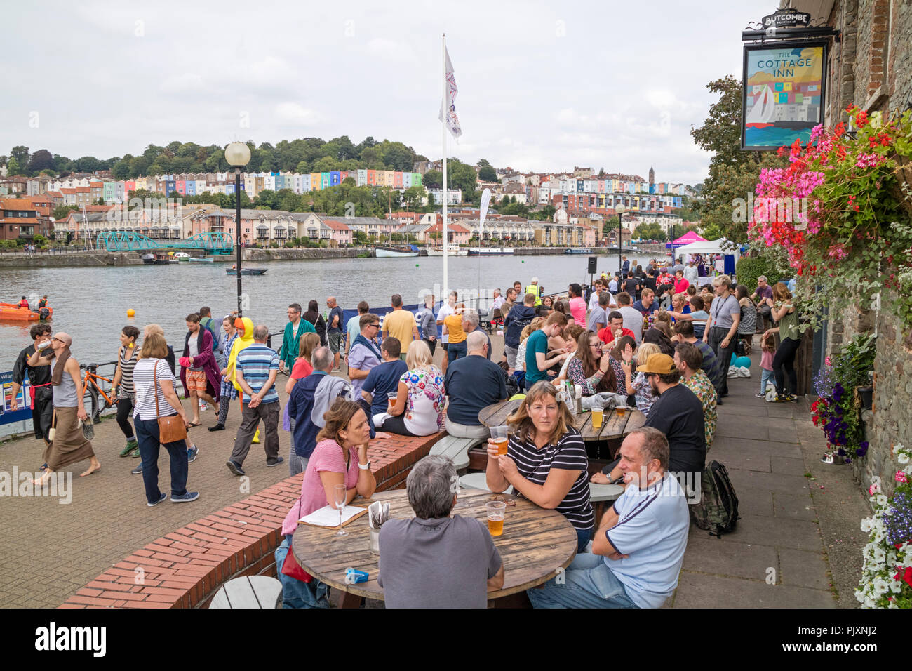 People relaxing at the Cottage Inn on the Harbourside, Bristol Harbour in city of Bristol, England, UK Stock Photo