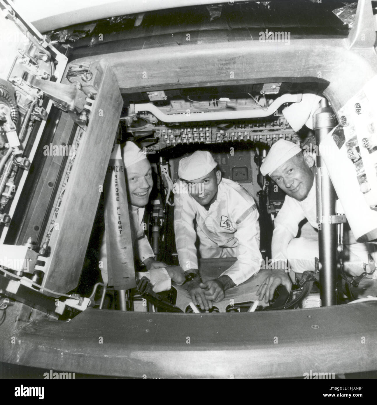 Cape Canaveral, FL - (FILE) -- The Apollo 11 crew conducting a crew compartment fit and functional check, of the equipment and storage locations, in their command module on June 10, 1969. Peering from the hatch are from left, Neil Armstrong, commander; Michael Collins, command module pilot; and Buzz Aldrin, lunar module pilot. Armstrong and Aldrin later conducted a similar check aboard the lunar module, which carried them down to the lunar surface on July 20, 1969. Credit: NASA via CNP /MediaPunch Stock Photo