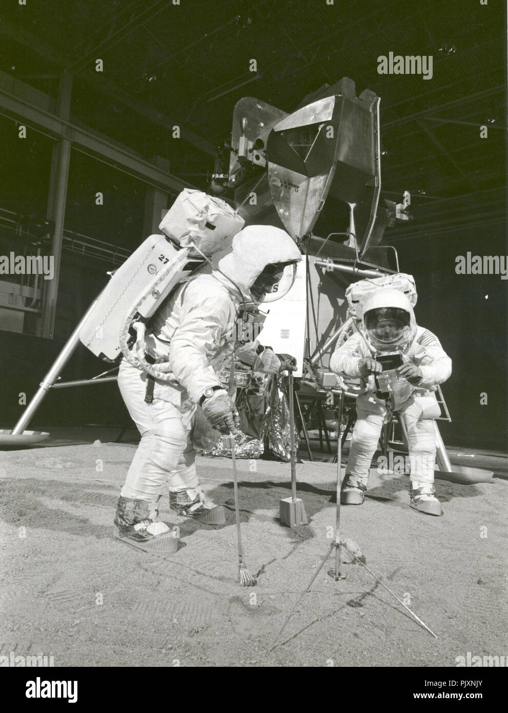 Houston, TX - (FILE) -- Two members of the Apollo 11 lunar landing mission participate in a simulation of deploying and using lunar tools on the surface of the Moon during a training exercise on April 22, 1969. Astronaut Buzz (Aldrin Jr. on left), lunar module pilot, uses a scoop and tongs to pick up a soil sample. Astronaut Neil A. Armstrong, Apollo 11 commander, holds a bag to receive the sample. In the background is a Lunar Module mockup. Credit: NASA via CNP /MediaPunch Stock Photo
