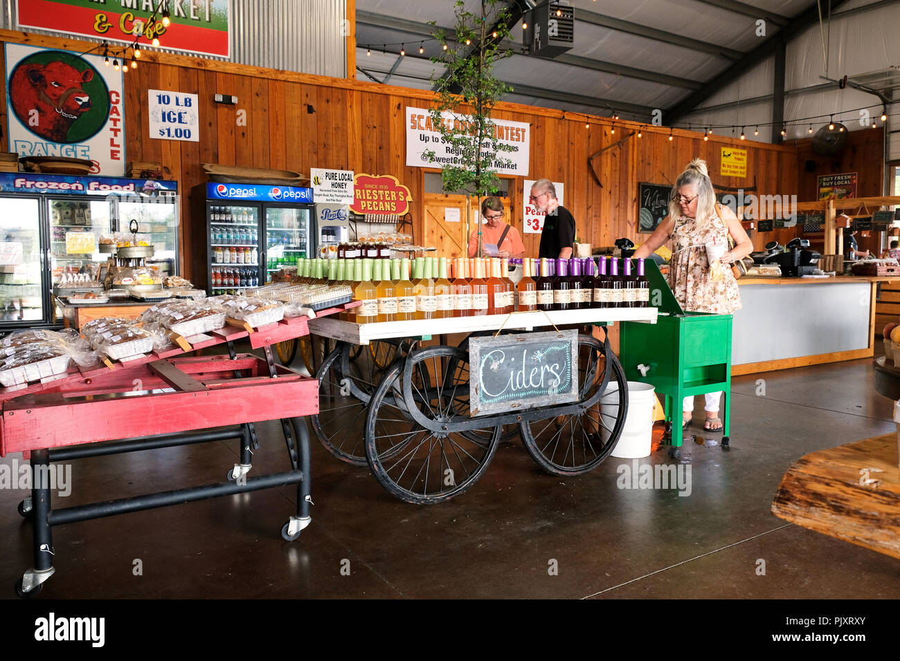People shopping at rural country store with display of old fashion apple cider, peach cider and muscadine cider in Pike Road Alabama, USA. Stock Photo