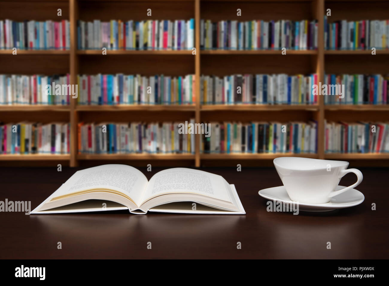 a book open on the desk with a cup of coffee. Stock Photo