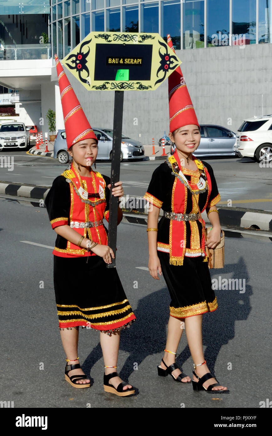 Two women in pointed hats leading a group during the Gawai parade, Kuching, Malaysia Stock Photo