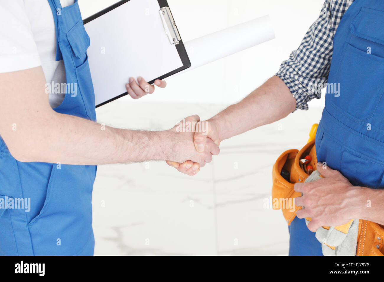 Two construction workers shaking hands, deal is finished concept Stock Photo