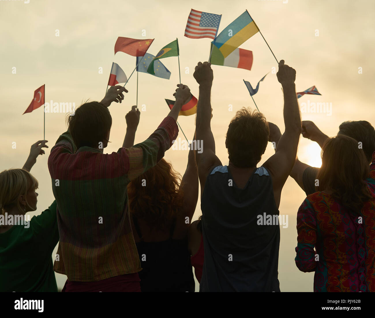 Silhouettes of people holding flags from various countries Stock Photo