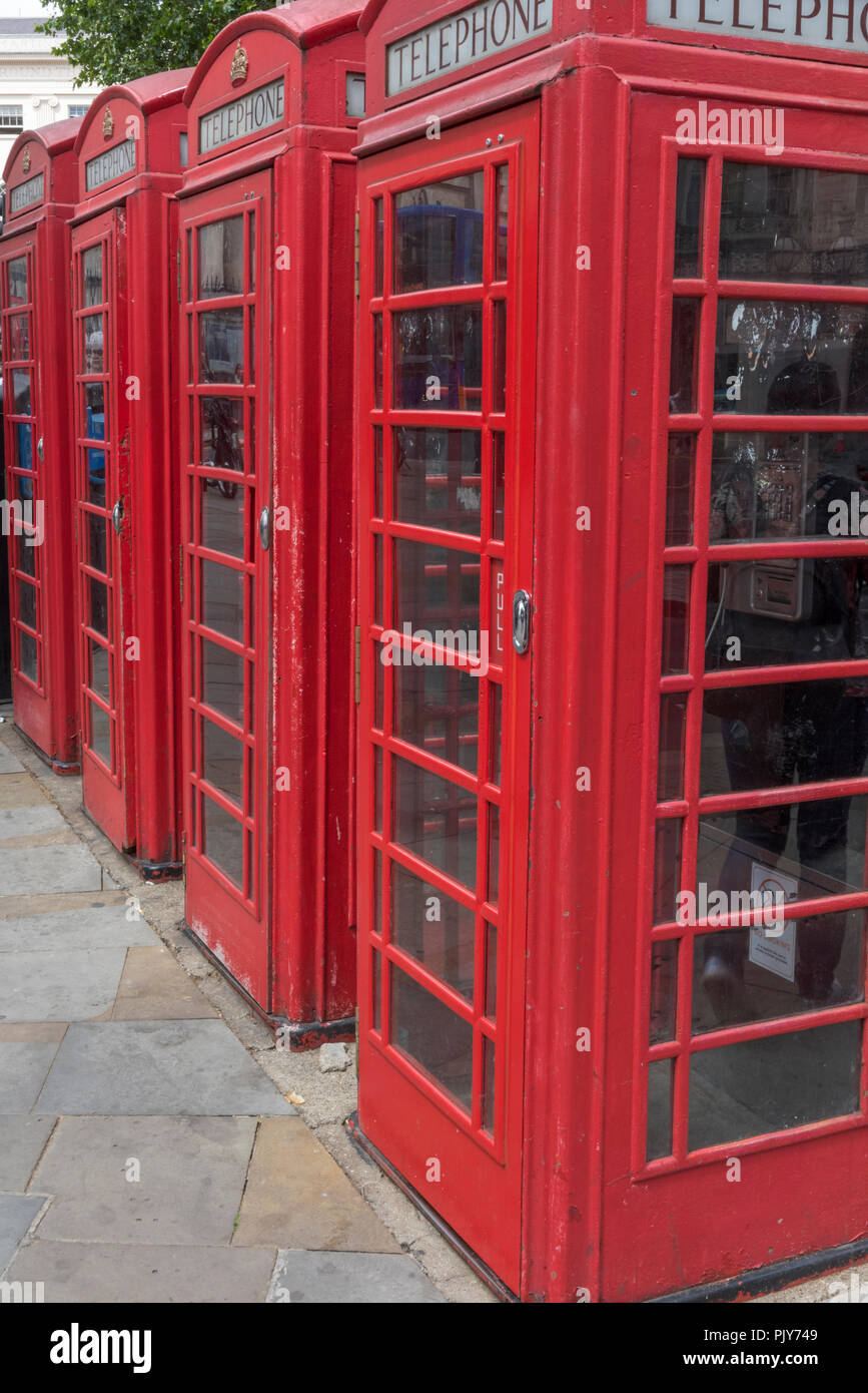 a row of traditional heritage red call or telephone boxes in central London. Stock Photo