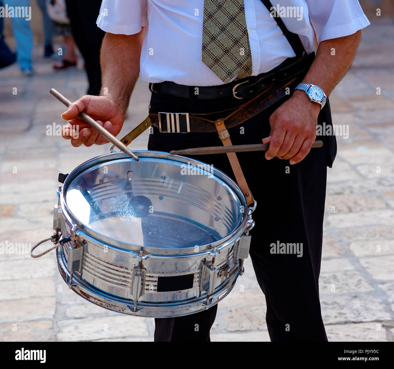 musician plays a drum on the street during a religious event Stock Photo