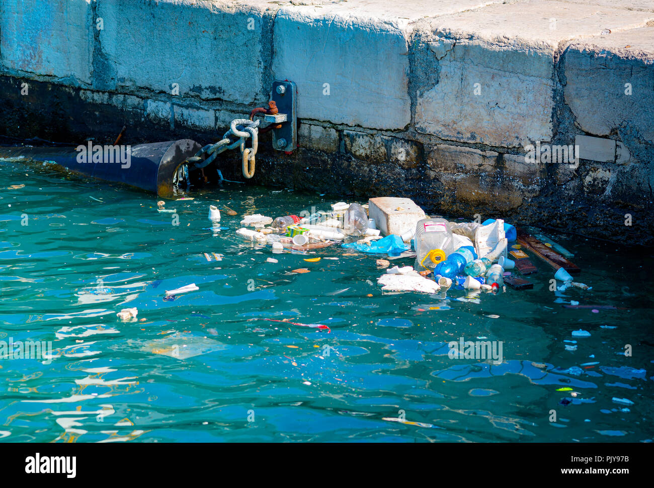 Beach pollution. Plastic bottles and other trash on sea port Stock Photo