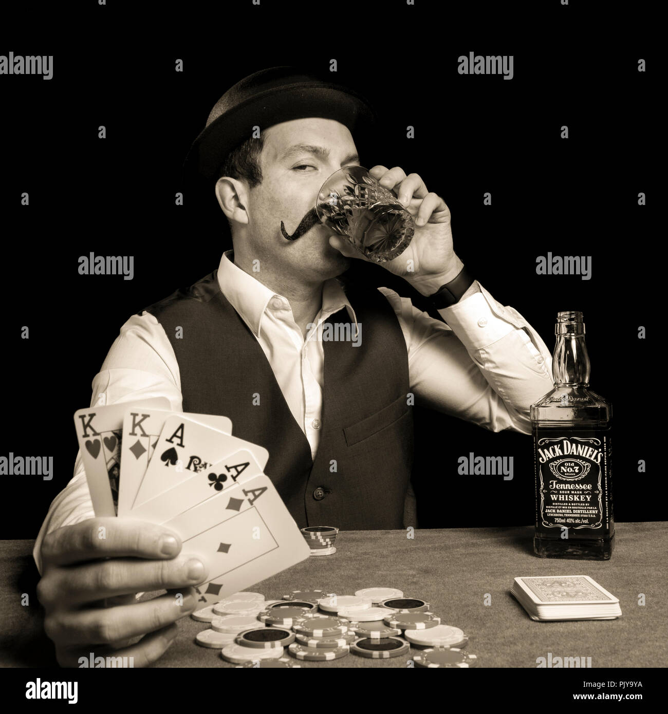 19th century man playing and winning a game of poker drinking a bottle of jack  daniel's whisky jack daniels melon hat alcohol Stock Photo - Alamy