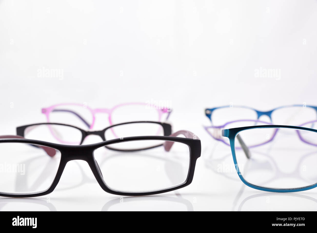 Stand of eyeglasses on white table in a eyewear store with. Front view. Horizontal composition Stock Photo