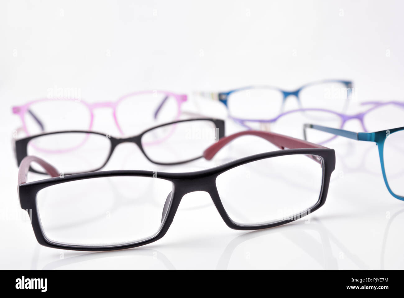 Stand of eyeglasses on white table in a eyewear store with. Front elevated view. Horizontal composition Stock Photo