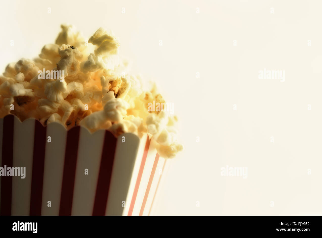 Popcorn in cardboard box with white background vintage. Horizontal composition. Front view. Stock Photo