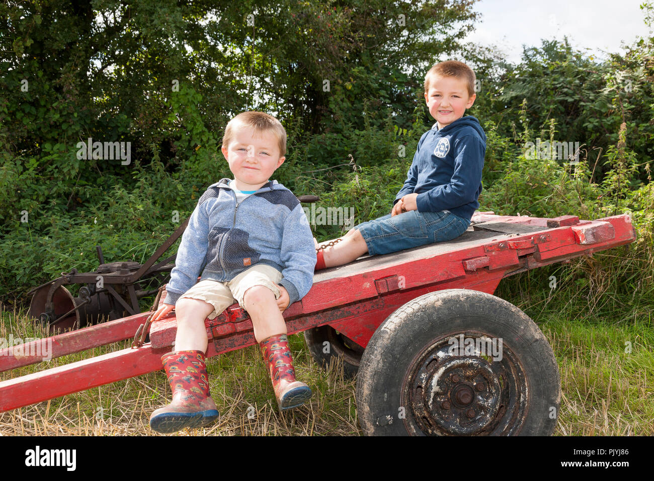Timoleague, Cork, Ireland. 9th September 2018. Brothers Conor and Daniel Walsh, Ballinascarthy take a rest on an old vintage cart at the West Cork Vintage Ploughing & Threshing event that was held at Barryshall Timoleague Co.Cork. Credit: David Creedon/Alamy Live News Stock Photo
