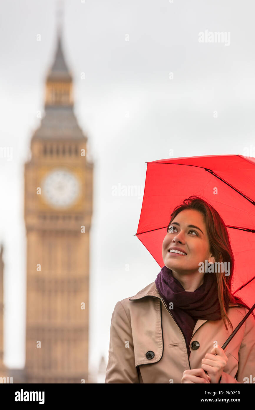 Girl or young woman tourist on vacation with a red umbrella with Big Ben in the background, London, England, Great Britain Stock Photo