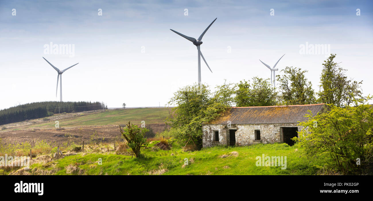 Ireland, Co Leitrim, Arigna, hilltop wind farm turbines beyond remote abandoned cottage, panoramic Stock Photo