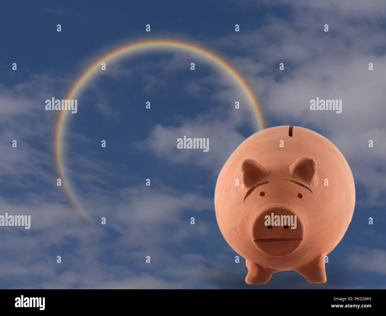 Terracotta pig money box with cloudy sky and rainbow. Money