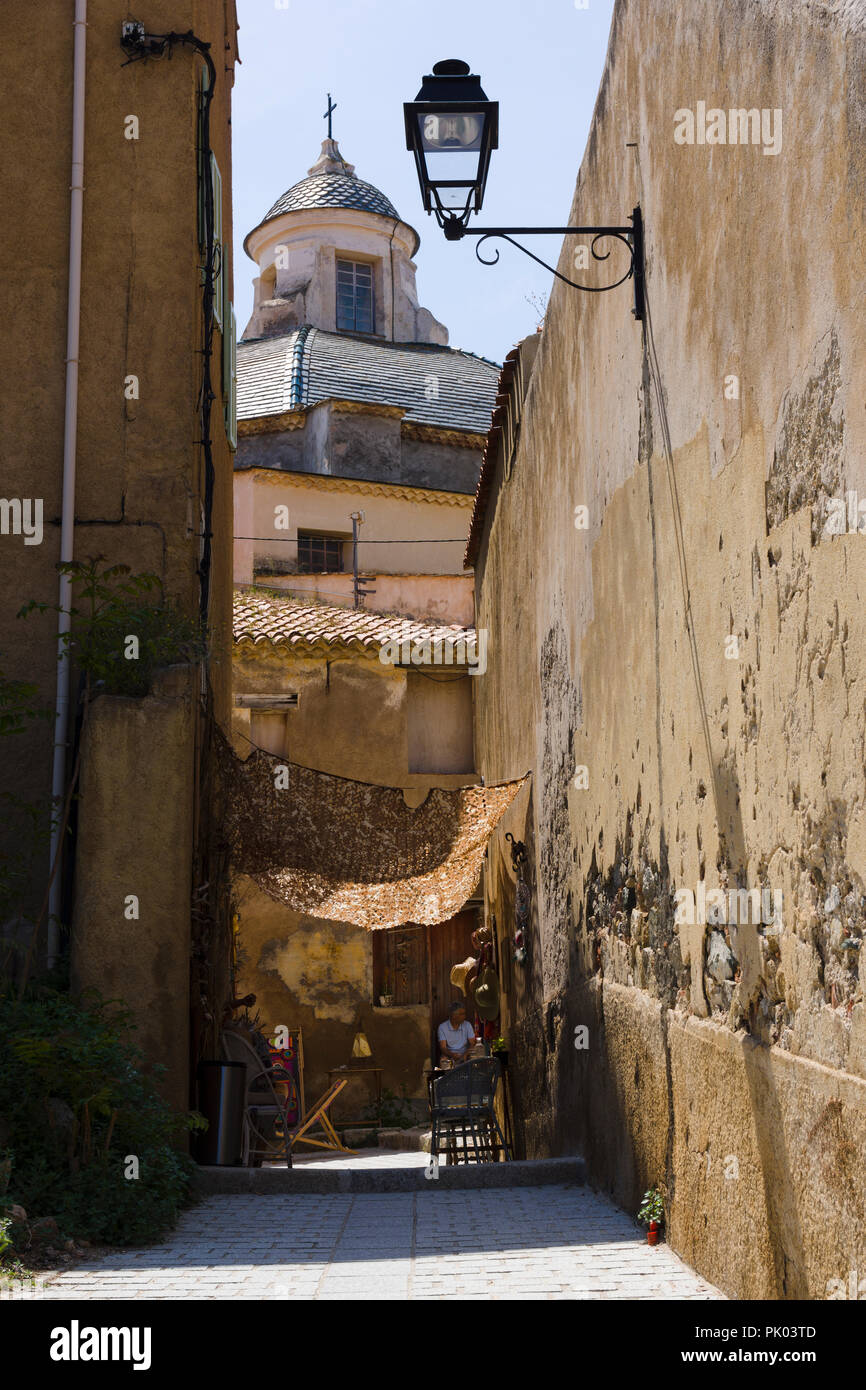 View through narrow alley towards Saint-Jean Baptiste cathedral in Calvi citadel, Corsica, France Stock Photo