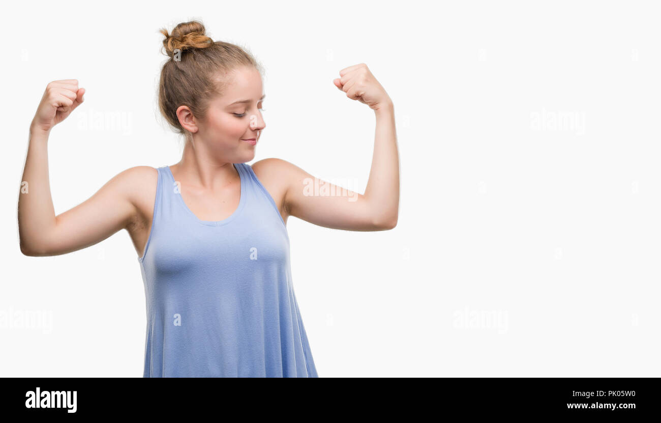Young blonde woman showing arms muscles smiling proud. Fitness concept. Stock Photo