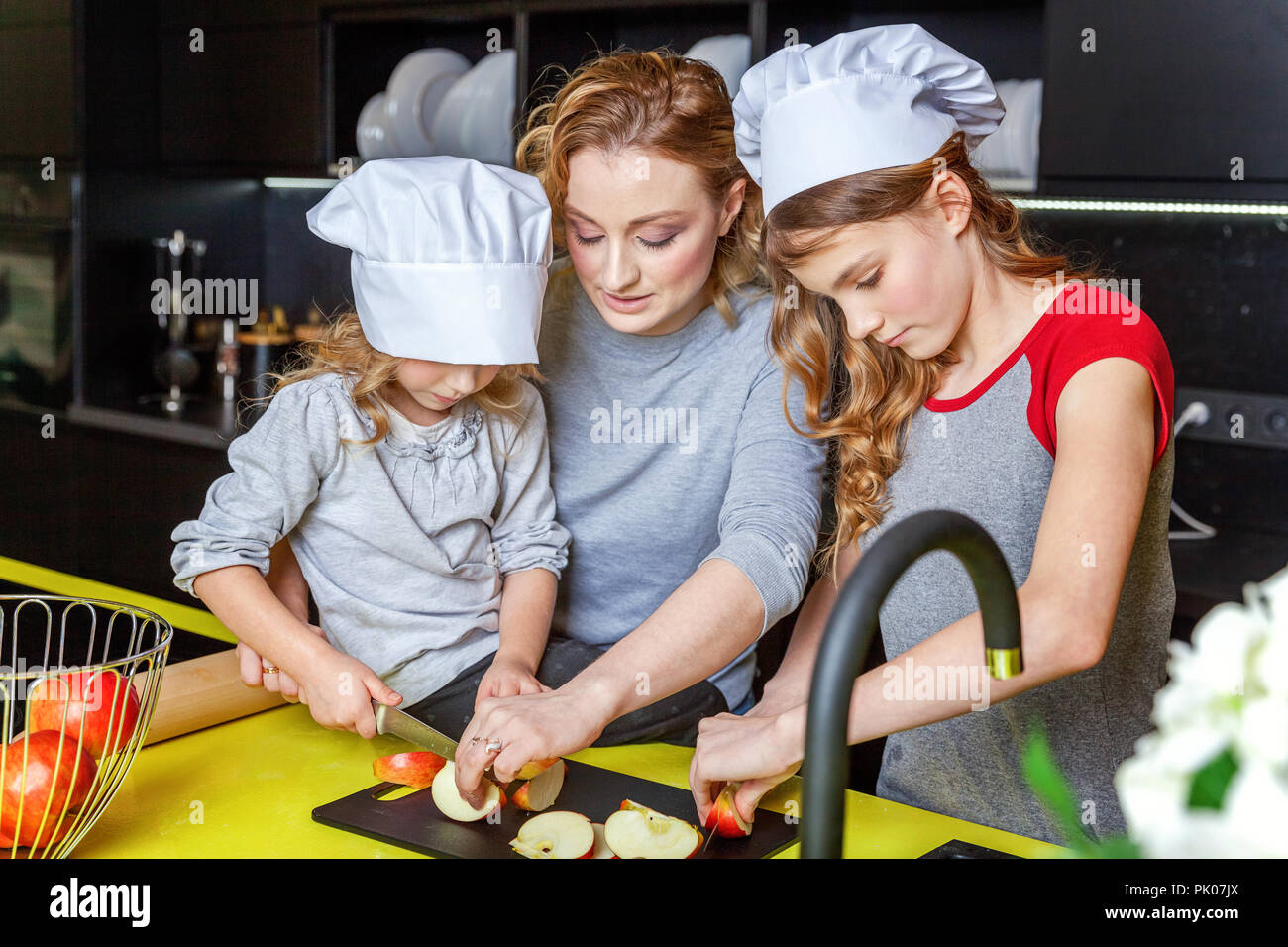 https://c8.alamy.com/comp/PK07JX/happy-family-in-kitchen-mother-and-two-children-preparing-dough-bake-apple-pie-mom-and-daughters-cooking-healthy-food-at-home-and-having-fun-house-PK07JX.jpg