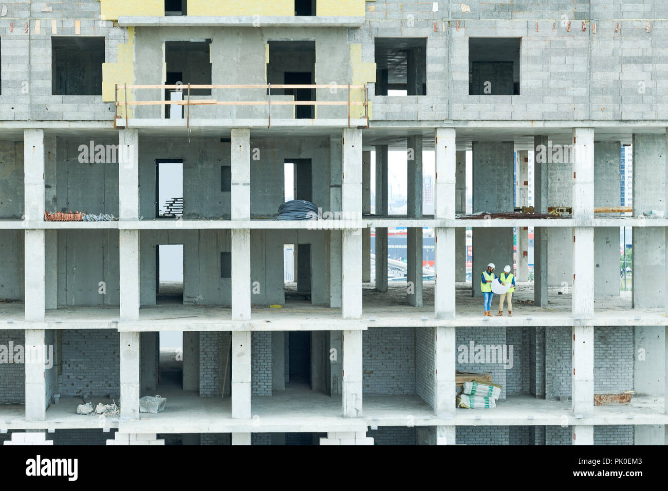 Building workers analyzing project plan Stock Photo