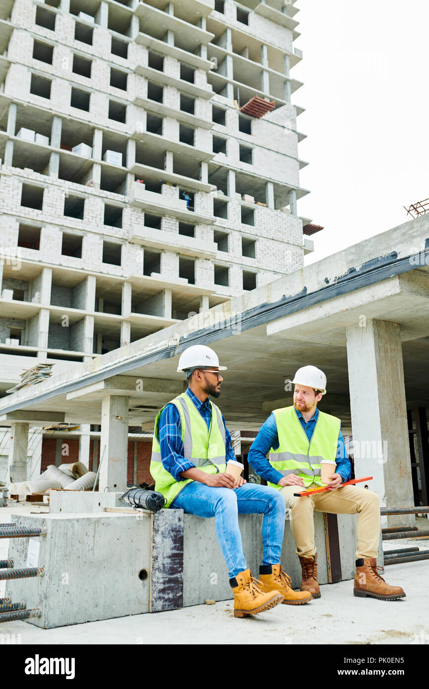 Multiethnic engineers having break at construction site Stock Photo