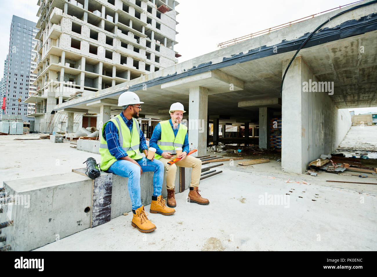 Positive builders relaxing on construction site Stock Photo