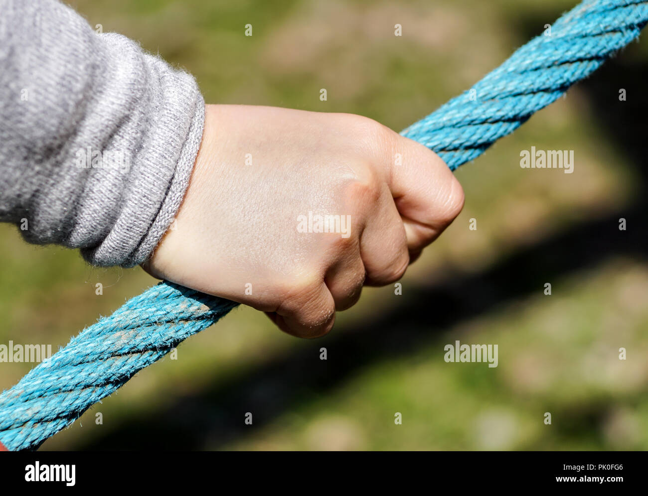 Children hand catching the rope with sunny day. Stock Photo