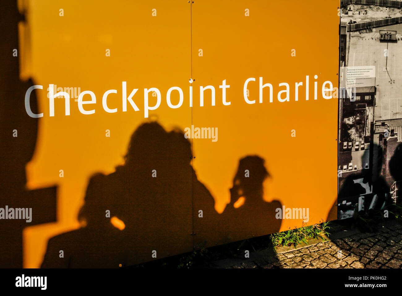 Shadows of tourists reflect on Billboards at the Checkpoint Charlie Museum in Berlin, Germany Stock Photo