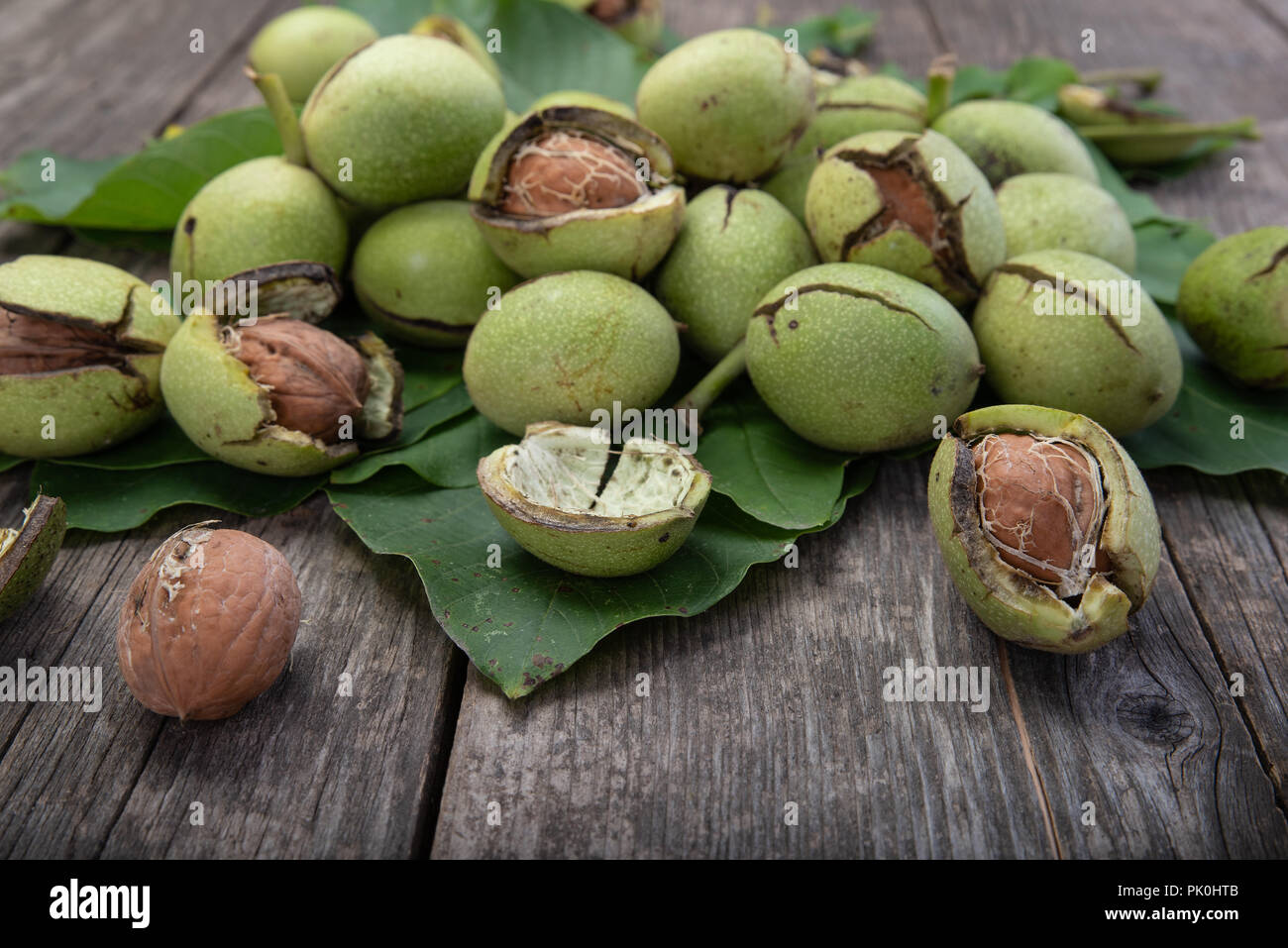 Group of fresh green walnuts on wooden table, autumn harvest Stock Photo Alamy