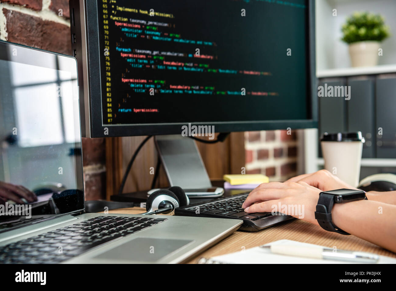the closeup view of typing codes on computer by female programmer's hand. Stock Photo