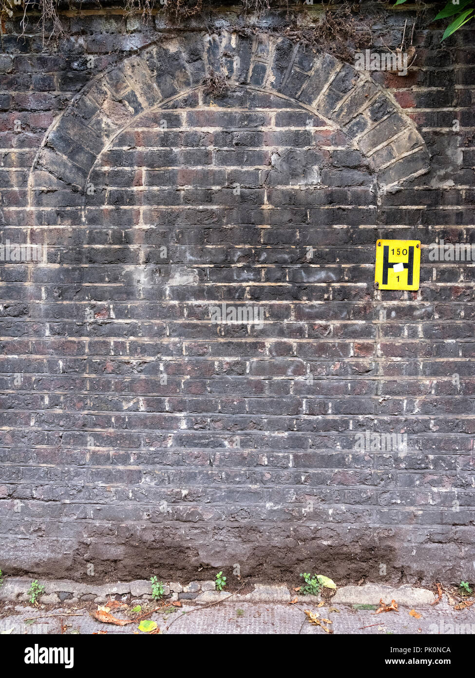 Evidence of an old doorway in an 18th century wall which encloses one of the oldest Jewish cemeteries in the UK in Brady Street, Whitechapel, London Stock Photo