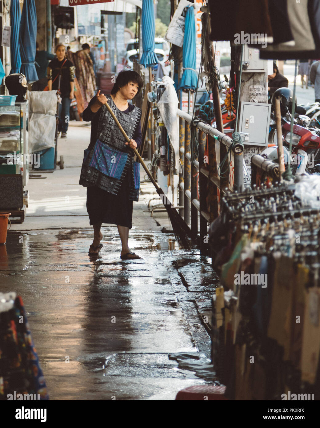 Woman sweeping at warorot market, Chinatown in Chiang Mai, Thailand Stock Photo