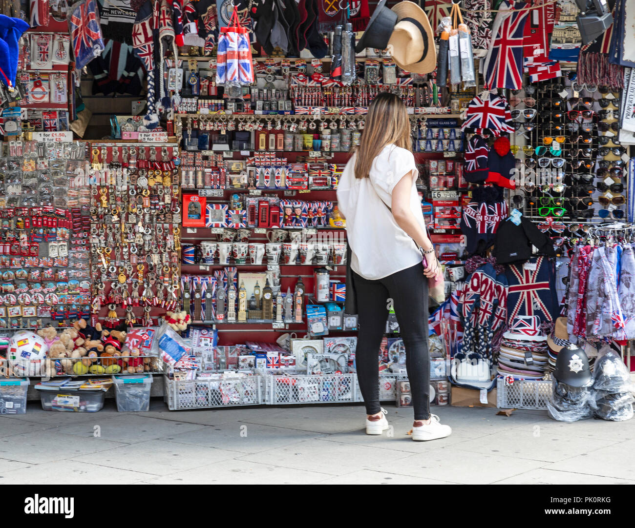 A young female tourist browses a stall in London, England, selling merchandise relating to London, England, and the UK. Stock Photo