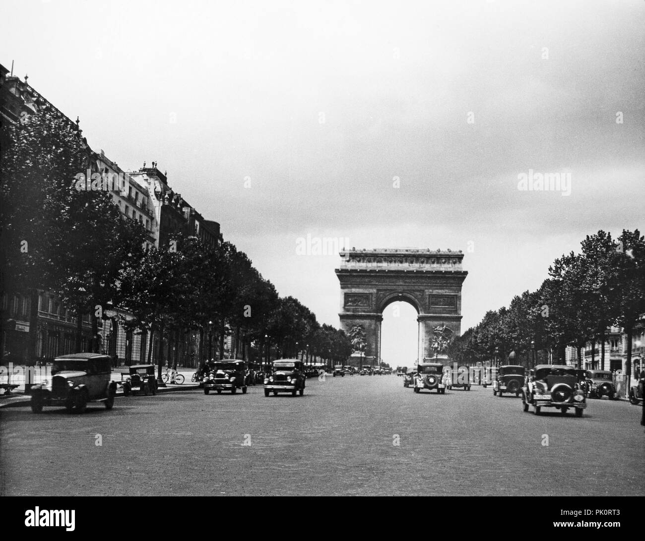 View of the Arc de Triumph in Paris, 1931, showing vehicles and fashion of the time. Stock Photo