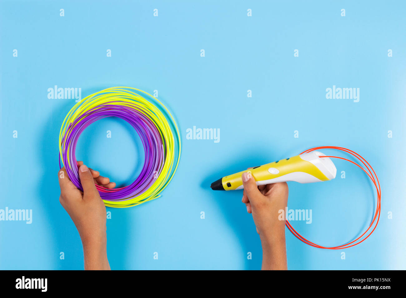 Child draws with 3d pen. Kid holding 3d pen with plastic filament Stock Photo