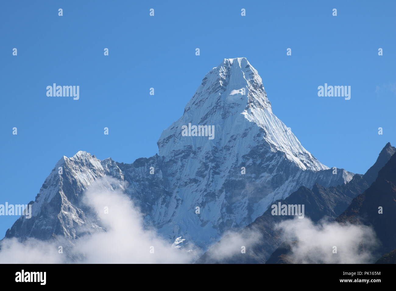 Amazing Shot of Nepalese himalayas mountain peaks covered with white snow and surrounded with light clouds attract many climbers and mountaineers Stock Photo