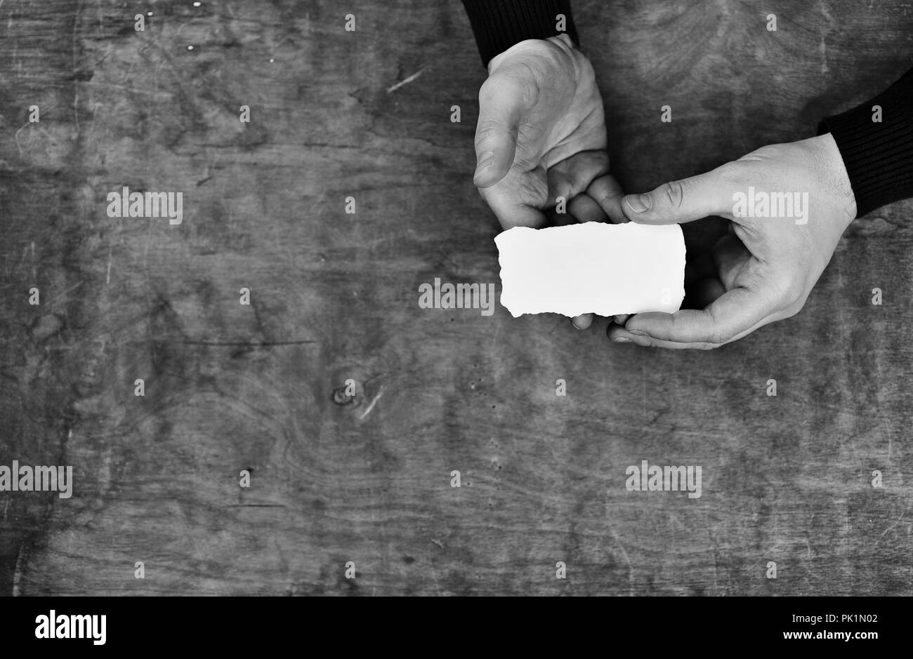 monochrome photo male hands holding a white blank sheet of paper Stock ...