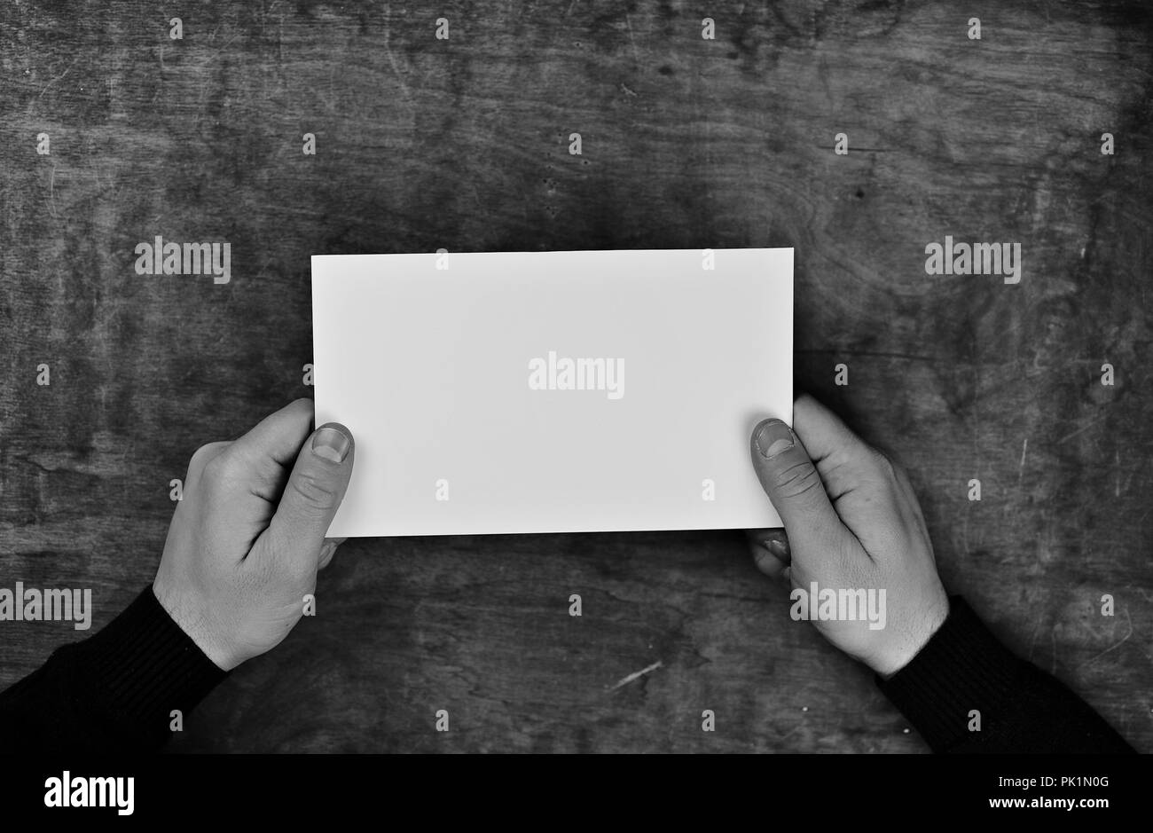 monochrome photo male hands holding a white blank sheet of paper Stock ...
