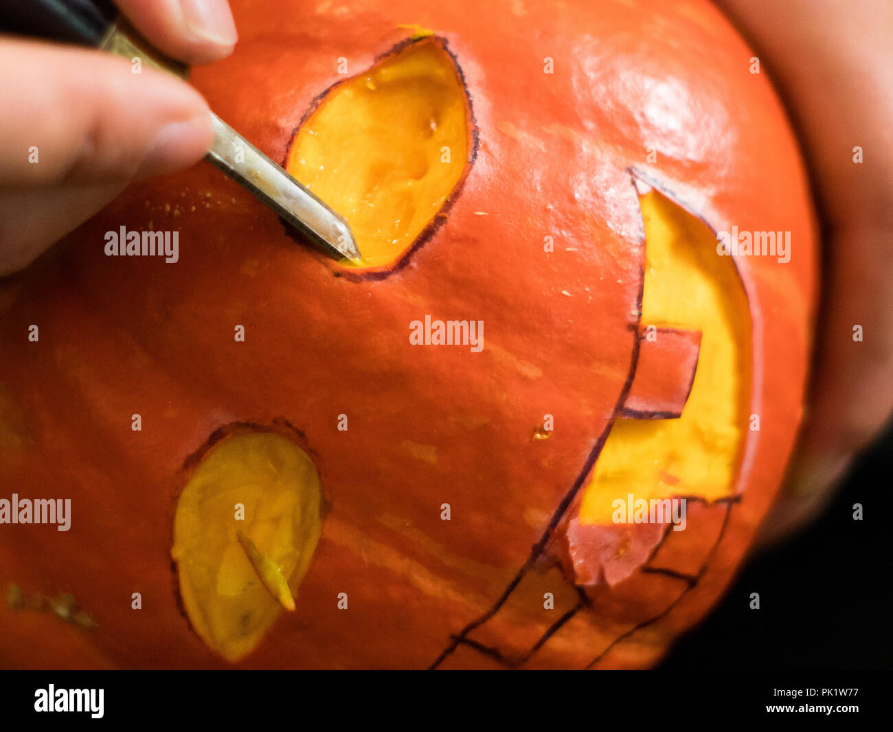 carving a Halloween pumpkin with a knife Stock Photo Alamy