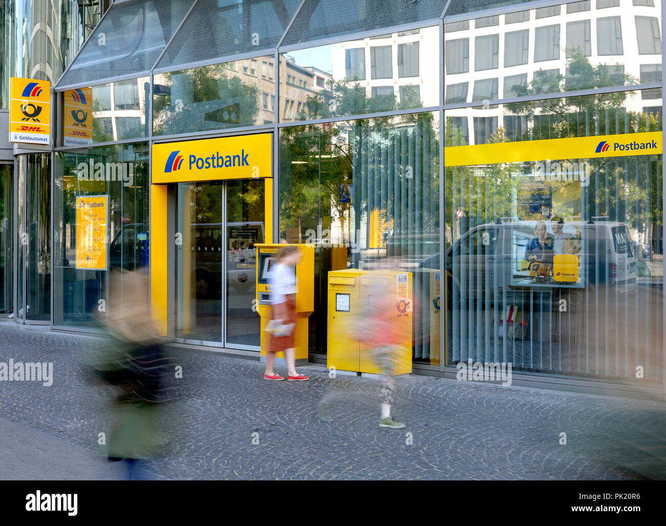 Frankfurt/Main, Germany - September 09, 2018: Postbank Office entrance with cash machine, letter box and blurred people in front Stock Photo