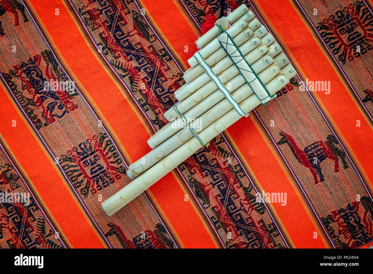 Pan flute on traditional andean fabric background Stock Photo
